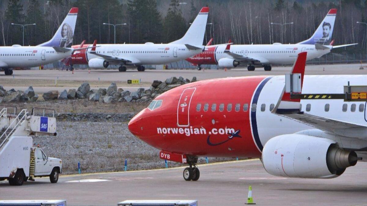 Low-cost Norwegian Air Shuttles line on the tarmac at Arlanda airport in Stockholm. Pressure from the airline may force American Airlines to add basic economy seats to international flights.