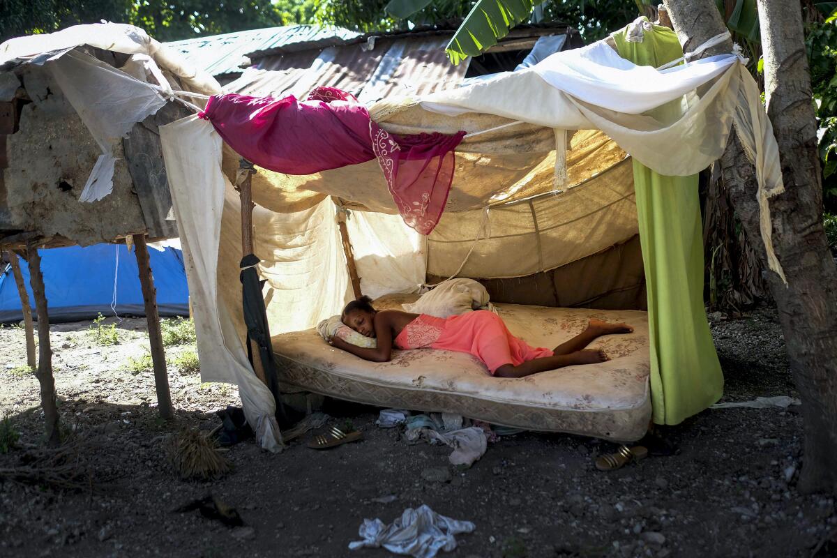 A woman sleeps outside her home in Saint-Louis-du-Sud, Haiti, Monday, Aug. 16, 2021, two days after a 7.2-magnitude earthquake struck the southwestern part of the country. (AP Photo/Matias Delacroix)