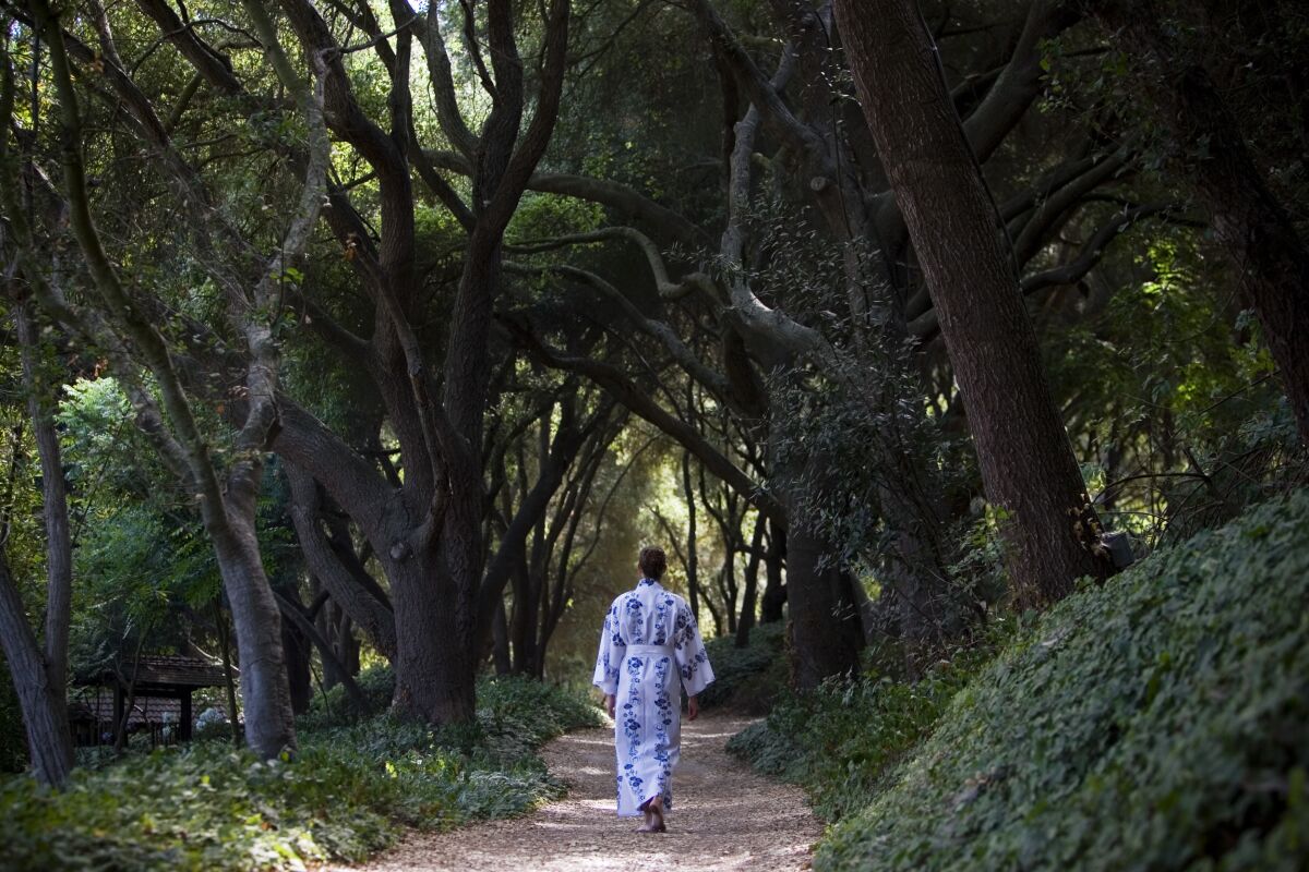 A kimono-wrapped woman walks through an archway of trees at Golden Door Spa in north San Diego County.