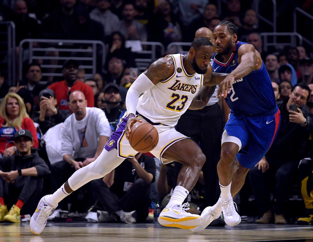 Lakers forward LeBron James drives on Clippers forward Kawhi Leonard during the Lakers' win on Sunday.