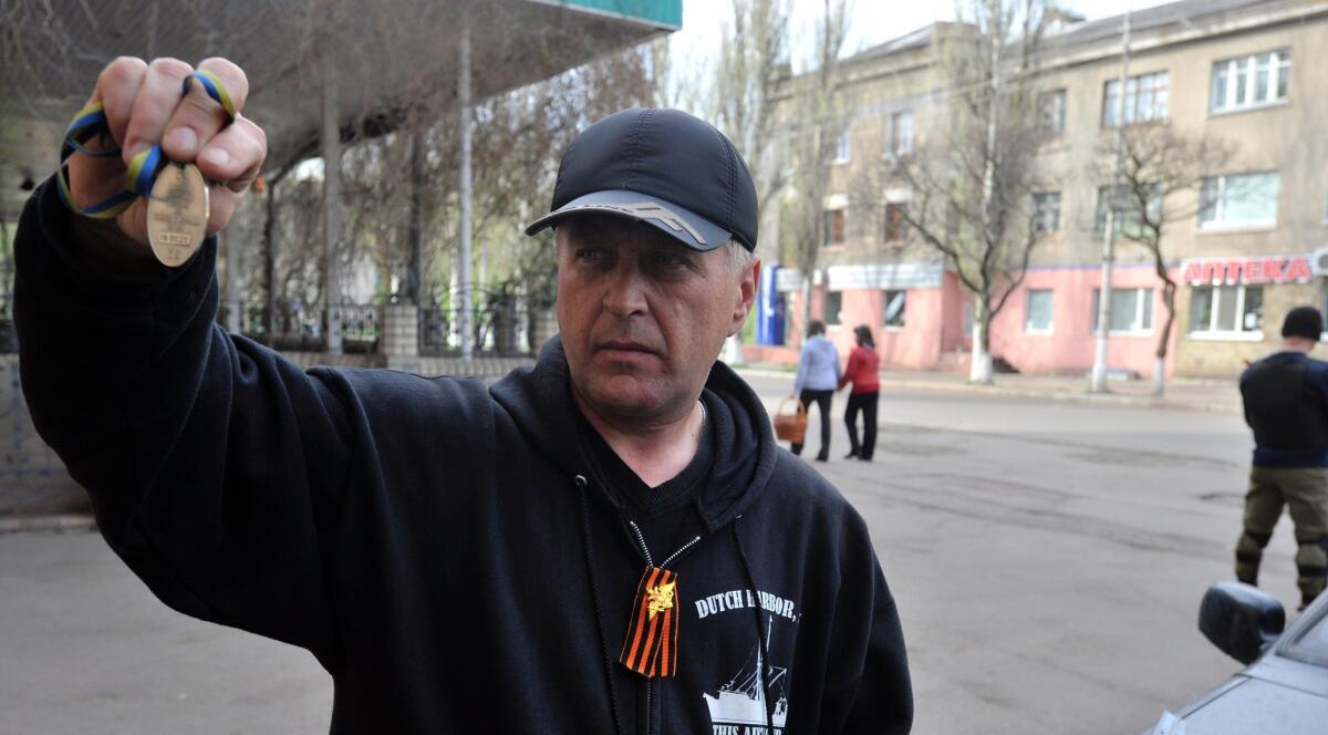 The self-styled separatist leader of Slovyansk, Vyacheslav Ponomaryov, shows what he says is a "badge of Right Sector fighters" found after a gun battle Sunday outside the eastern Ukrainian city of Slovyansk.
