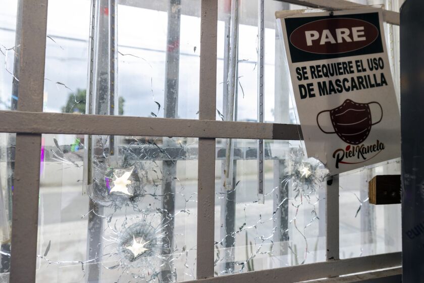 Bullet holes pierce a front window at the Piel Kanela bar in San Juan, Puerto Rico, Monday, May 29, 2023. Assailants killed two people and injured 13 the previous day when they fired indiscriminately outside the bar during a birthday party, according to police. (AP Photo/Alejandro Granadillo)