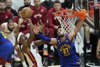 Miami Heat forward Jimmy Butler (22) drives to the basket as Denver Nuggets guard Jamal Murray (27) defends.