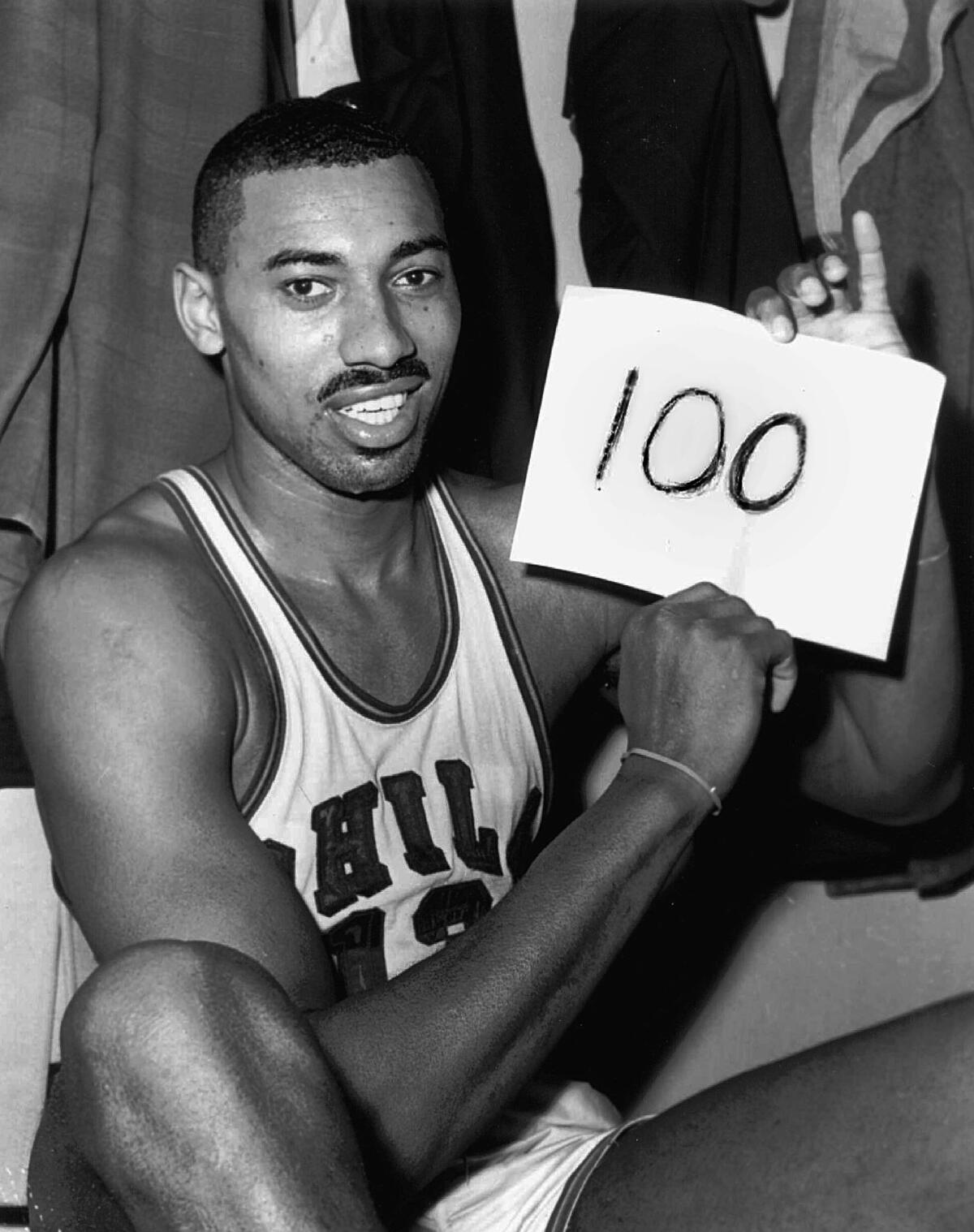 On March 2, 1962, Wilt Chamberlain of the Philadelphia Warriors holds a sign reading "100" after he scored 100 points.