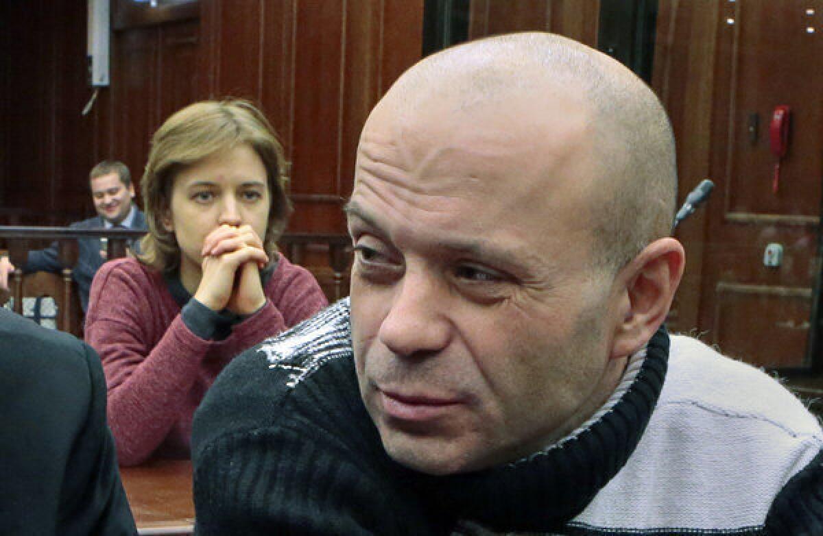 Anna Politkovskaya's daughter Vera, background, looks at former police officer Dmitry Pavlyuchenkov, right, prior to the judge's verdict being rendered in his case in Moscow City Court on Friday.