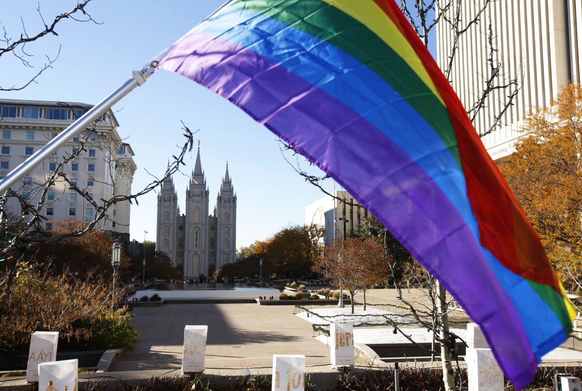 A pride flag flies in front of the Salt Lake Temple in Salt Lake City during a protest by Mormons who resigned en masse Saturday from the church.