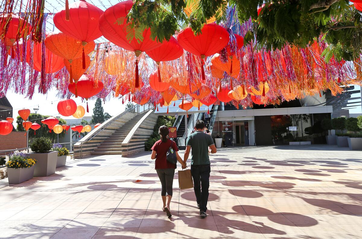 Shoppers under a ceiling of red lanterns Friday on South Coast Plaza's Garden Terrace to mark the Autumn Harvest Festival.