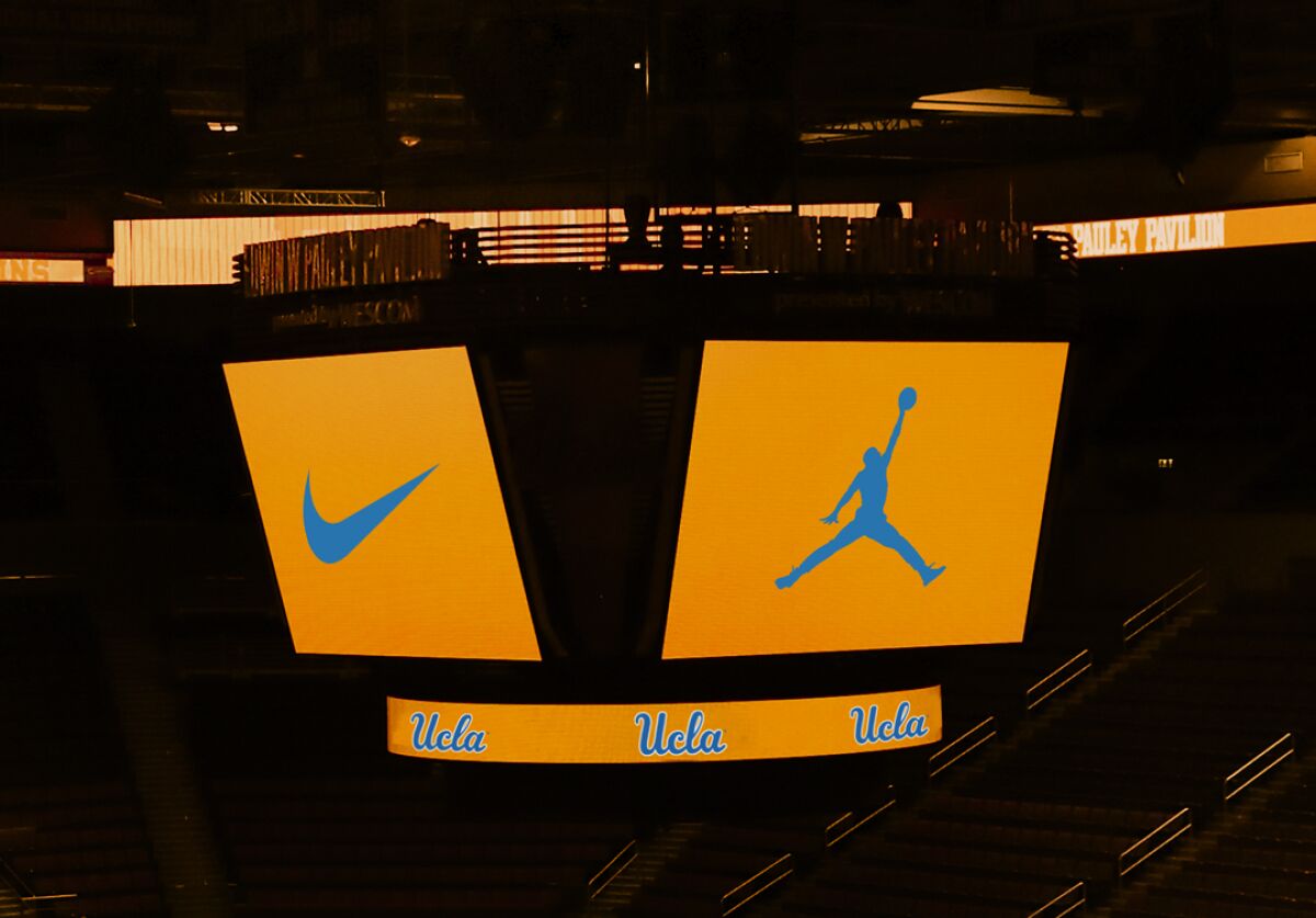 The UCLA basketball court with Jordan Brand and Nike logos illuminating the scoreboard.