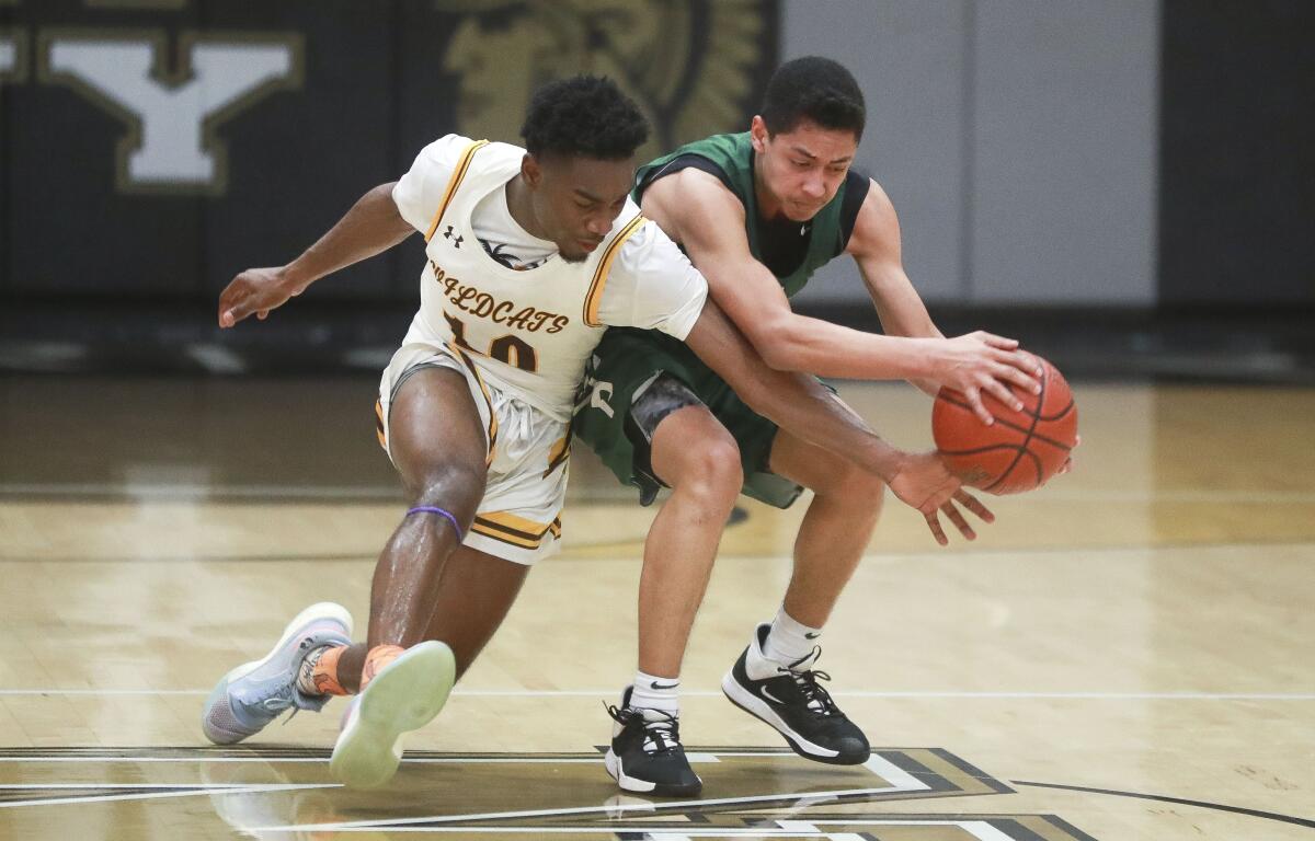 Providence High boys' basketball player Bryce Whitaker, right, and Oceanside El Camino's Tyson Robinson go for a loose ball during a CIF State Division III Southern California Regional game Thursday at Army-Navy Academy in Carlsbad.