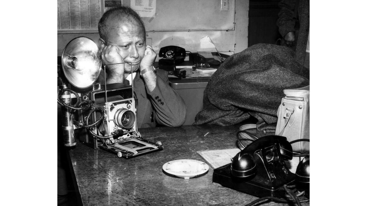 Aug. 23, 1954: Los Angeles Mirror photographer George Lacks portrays frustration after a narcotics suspect huddled under a blanket refused to come out and have his picture taken at the Central Police Station. 