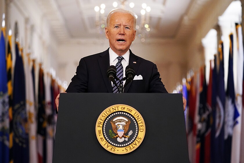 President Biden speaks at a lectern with the presidential seal on it.