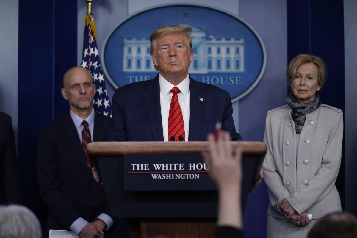 President Trump takes questions during a news briefing Thursday, flanked by Dr. Stephen Hahn, commissioner of the FDA, and Dr. Deborah Birx, White House coronavirus response coordinator.