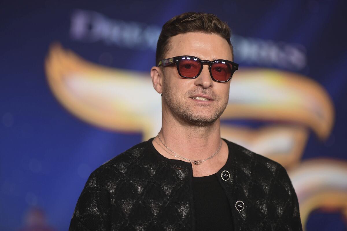 Justin Timberlake smiling in sunglasses, a dark jacket and a black T-shirt