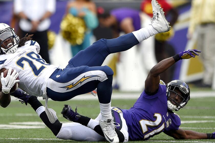 Chargers running back Melvin Gordon (28) is brought down by Ravens cornerback Lardarius Webb (21) in the second half Sunday.