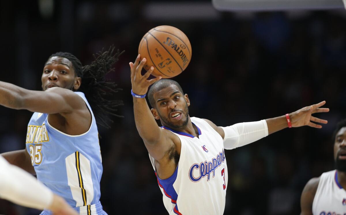 Clippers point guard Chris Paul grabs a defensive rebound after Nuggets power forward Kenneth Faried swiped at and missed the ball during a game last season.