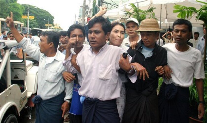 In a Tuesday, Aug. 28, 2007 file photo, pro-democracy demonstrators link arms to try to protect prominent labor activist Su Su Nway (woman, center) from arrest during a protest in Yangon, Myanmar. Su Su Nway, was sentenced to 12� years in prison Tuesday, Nov. 11, 2008 by courts in military-ruled Myanmar. The court also sentenced some two dozen other activists to harsh prison terms on Tuesday that will keep them behind bars far past a 2010 election. (AP Photo, File)