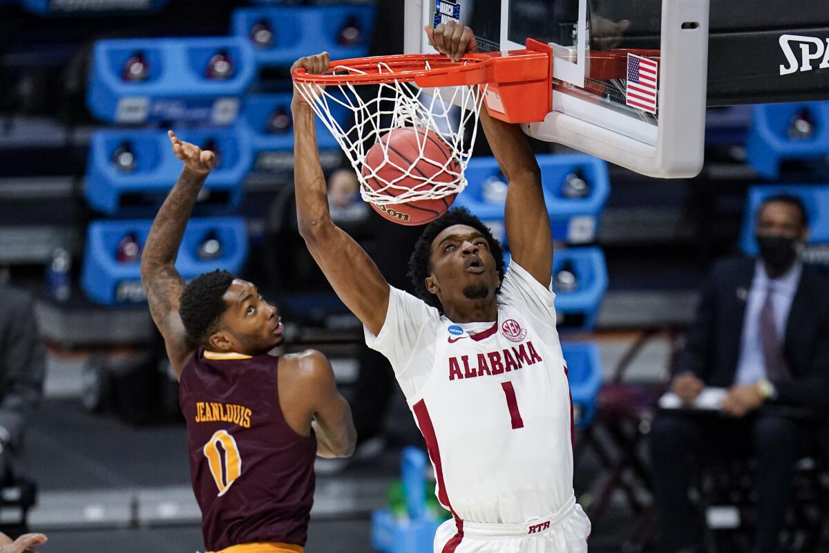 Alabama forward Herbert Jones dunks over Iona guard Berrick JeanLouis.