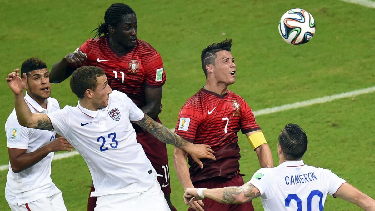 Portugal forward Cristiano Ronaldo, second right, jumps for the ball during a 2-2 tie with the United States in a Group G World Cup match Sunday.