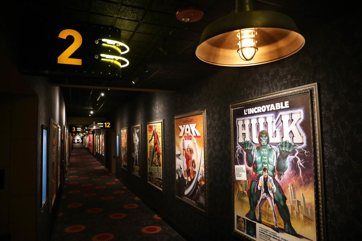 A hallway filled with vintage movie posters from around the world connects the theaters at the Alamo Drafthouse LA
