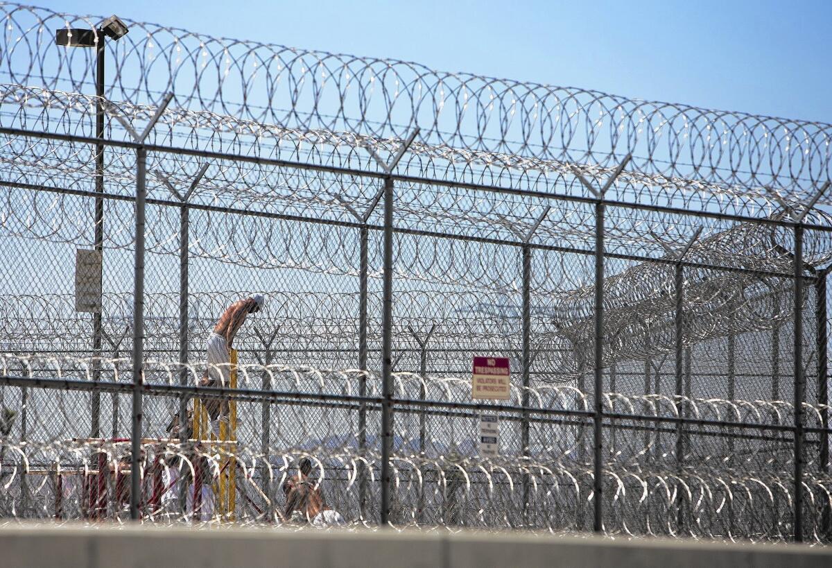 Detainees work in the yard at the Adelanto Detention Center. The facility is undergoing an expansion to add 650 beds, including a women's housing unit. The center currently has the capacity to hold 1,300 men.