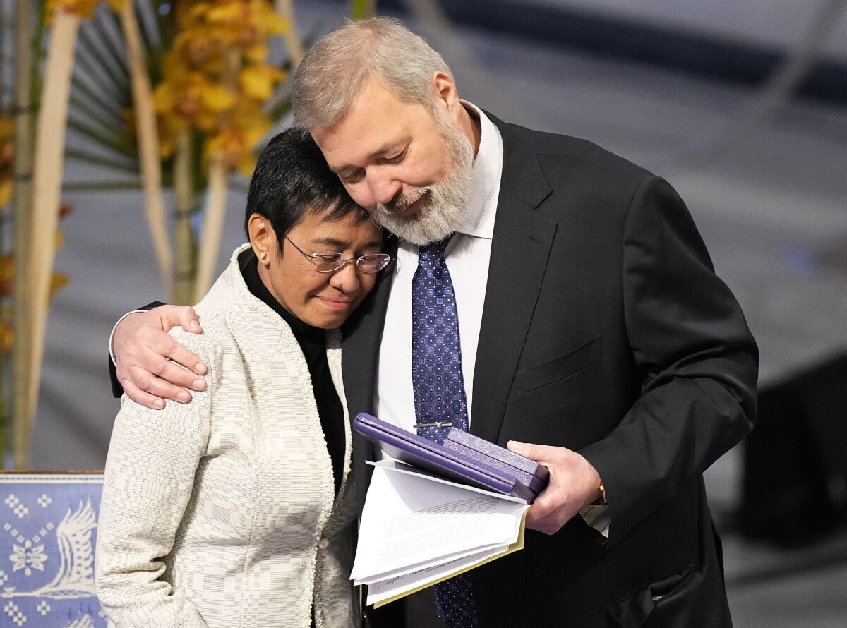Nobel Peace Prize winners Dmitry Muratov from Russia, right, and Maria Ressa of the Philippines embrace during the Nobel Peace Prize ceremony at Oslo City Hall, Norway, Friday, Dec. 10, 2021. The Norwegian Nobel Committee cited Ressa and Muratov's fight for freedom of expression, stressing that it is vital in promoting peace. (AP Photo/Alexander Zemlianichenko)