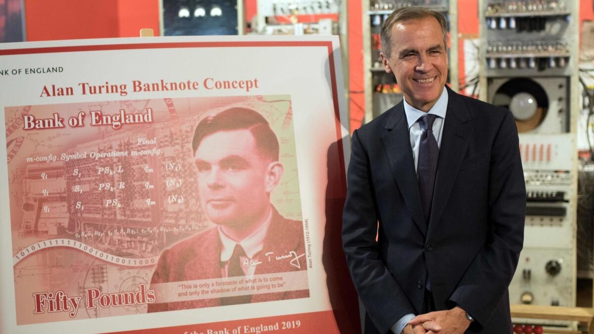 Mark Carney, governor of the Bank of England, poses for a photo beside the concept design for the new Bank of England 50-pound note featuring Alan Turing.