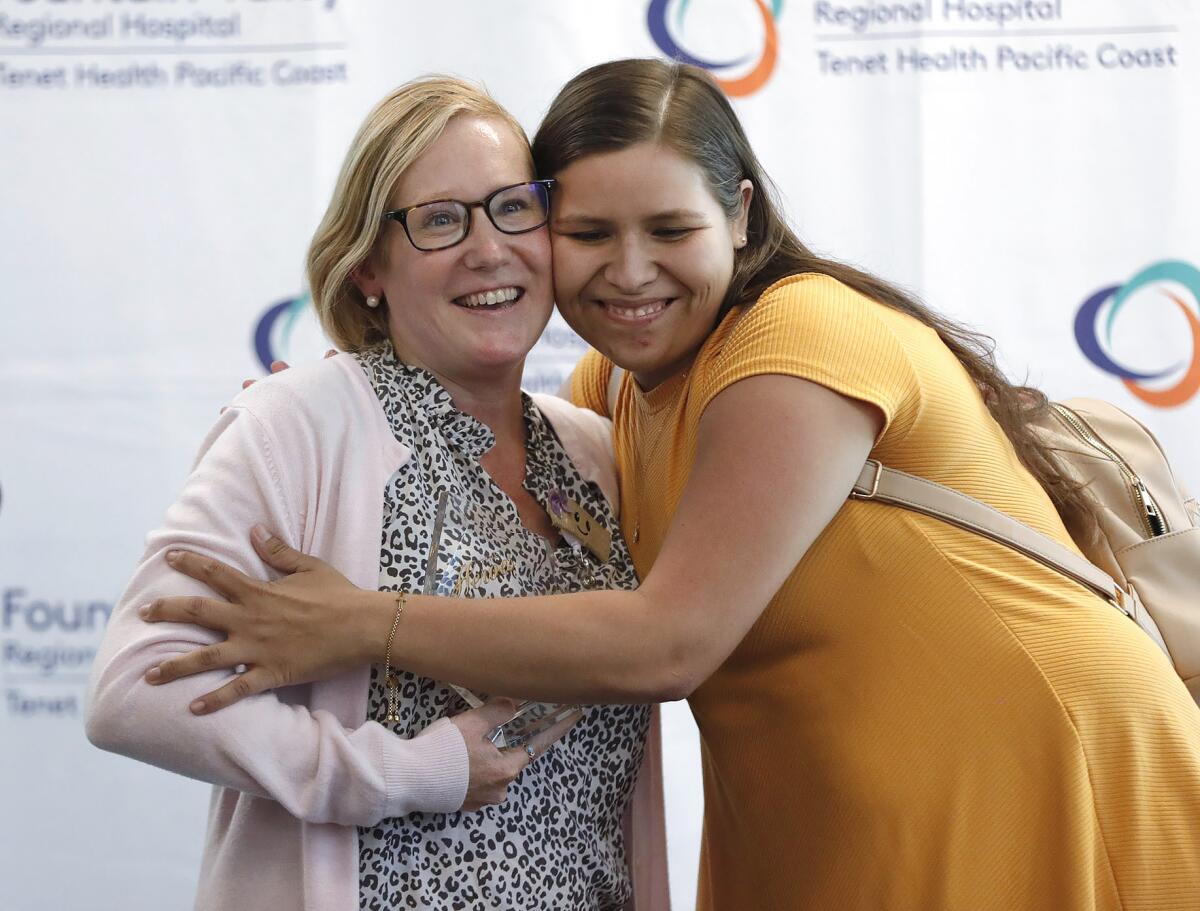 Adrienne Feilden, left, is hugged by nursing student Judit Ramirez, who was mentored by Feilden at the hospital.