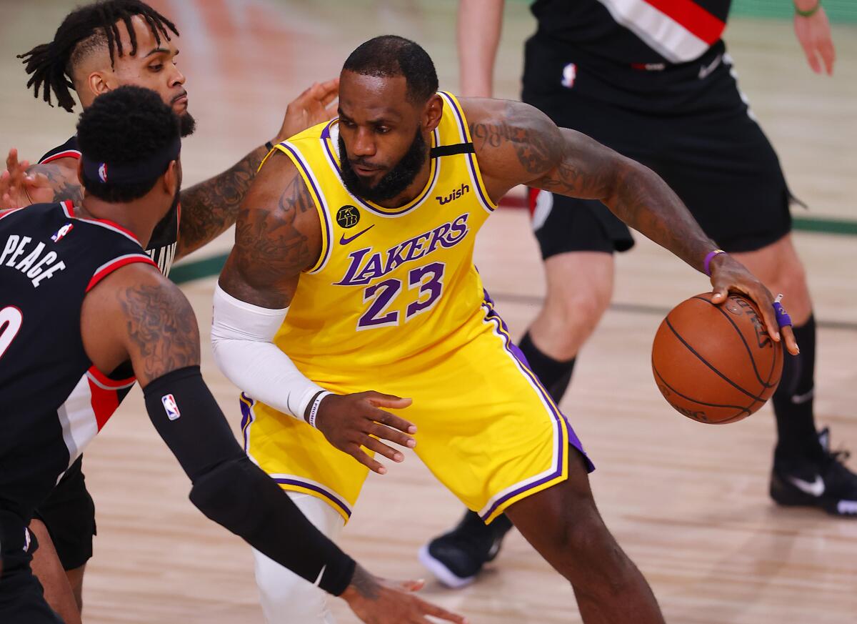 Lakers forward LeBron James tries to drive on the Portland Trail Blazers during the first half.