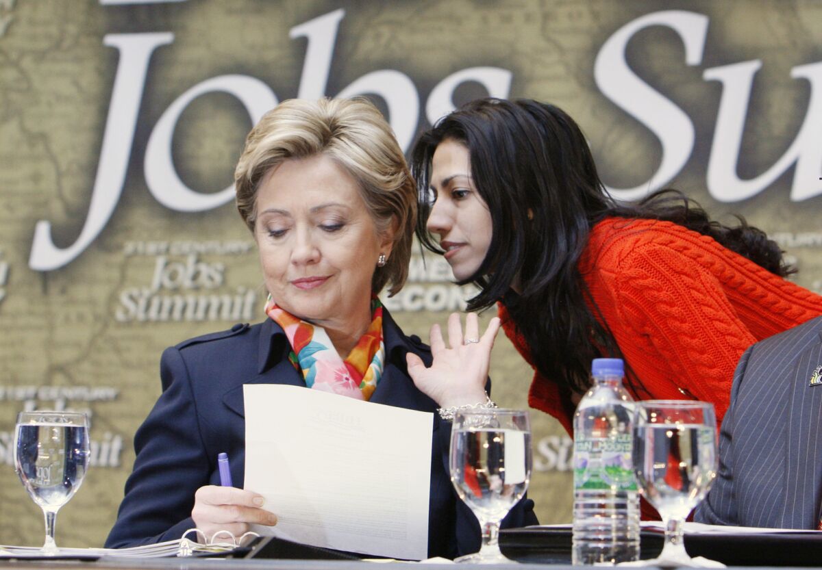 Then-Sen. Hillary Clinton, left, speaks with aide Huma Abedin before a presidential campaign event in Pittsburgh in 2008. A conservative advocacy group is seeking records related to Abedin's later State Department employment.