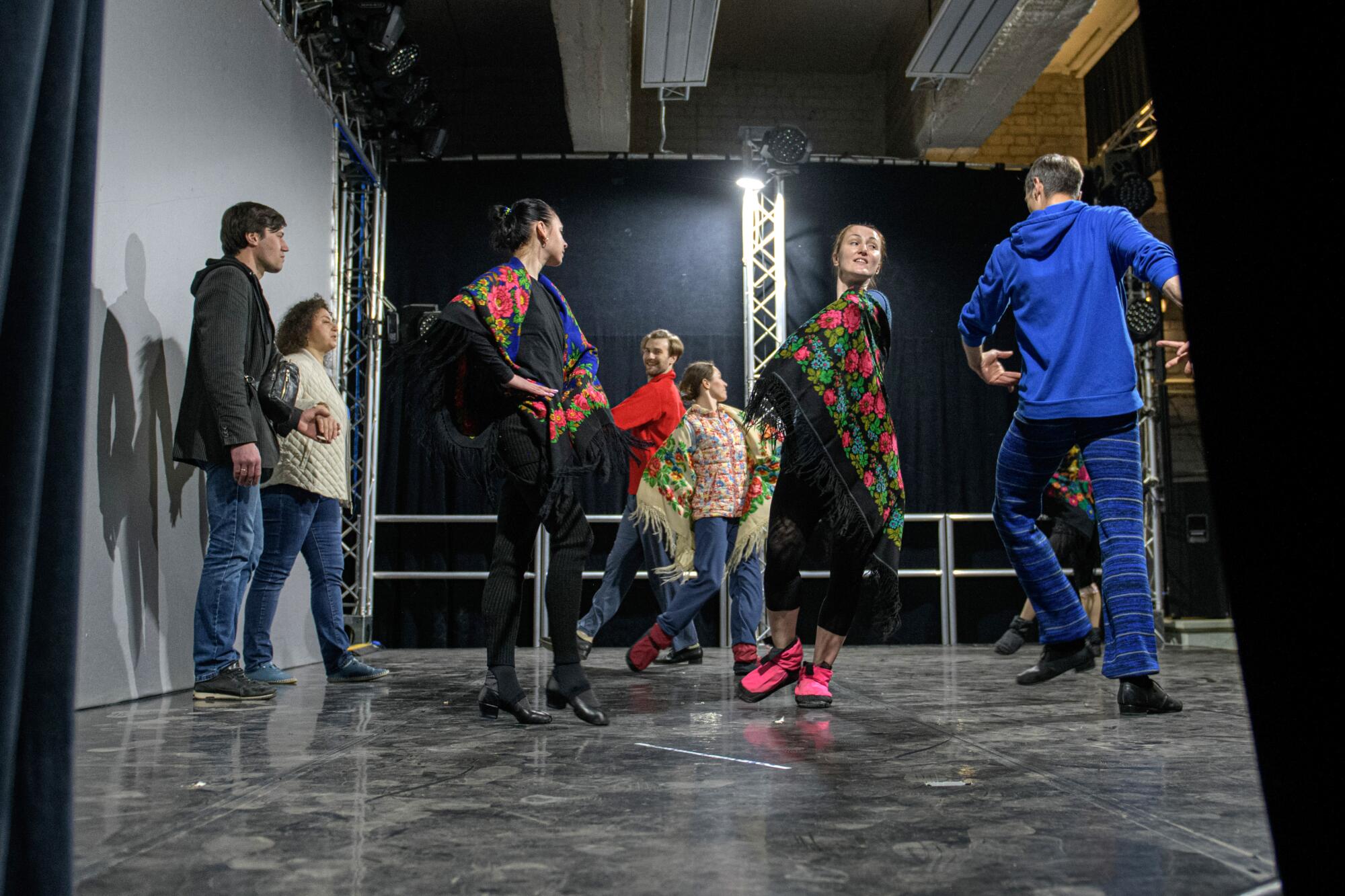 People in colorful clothing take part in a rehearsal.