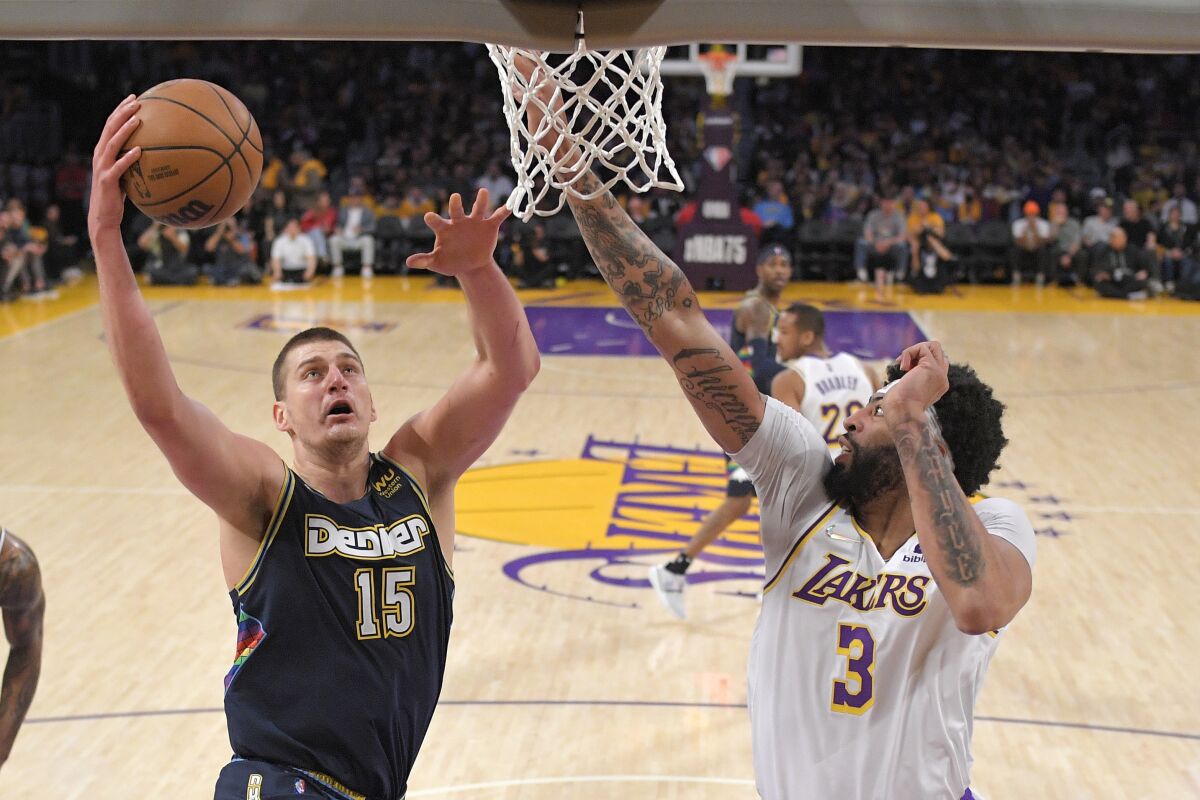 Nuggets center Nikola Jokic, left, attempts a layup as Lakers forward Anthony Davis tries to block the shot.