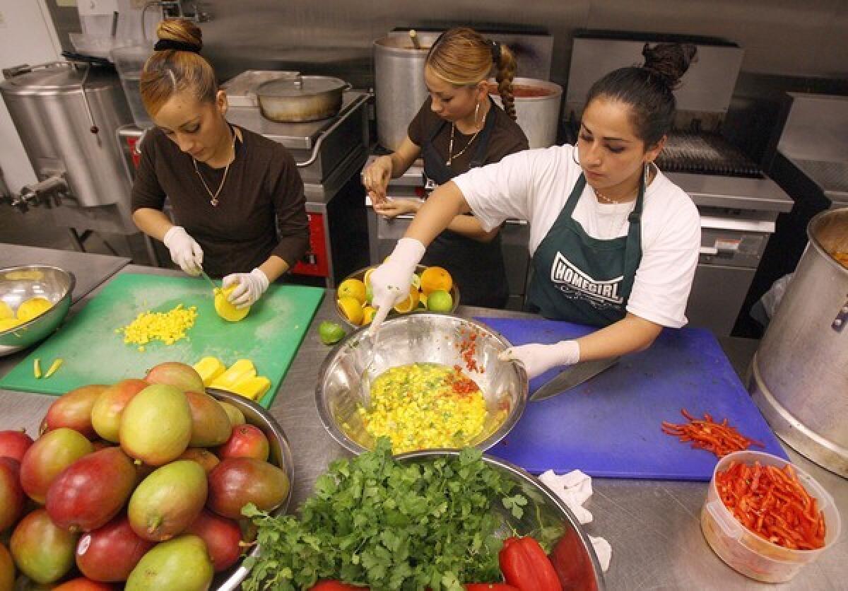 Homegirl Cafe & Catering workers Alma Cova, left, Abbigale Vasquez and Jessica Perez make mango salsa, one of two varieties to be sold at the Ralphs on West 9th Street in downtown Los Angeles.