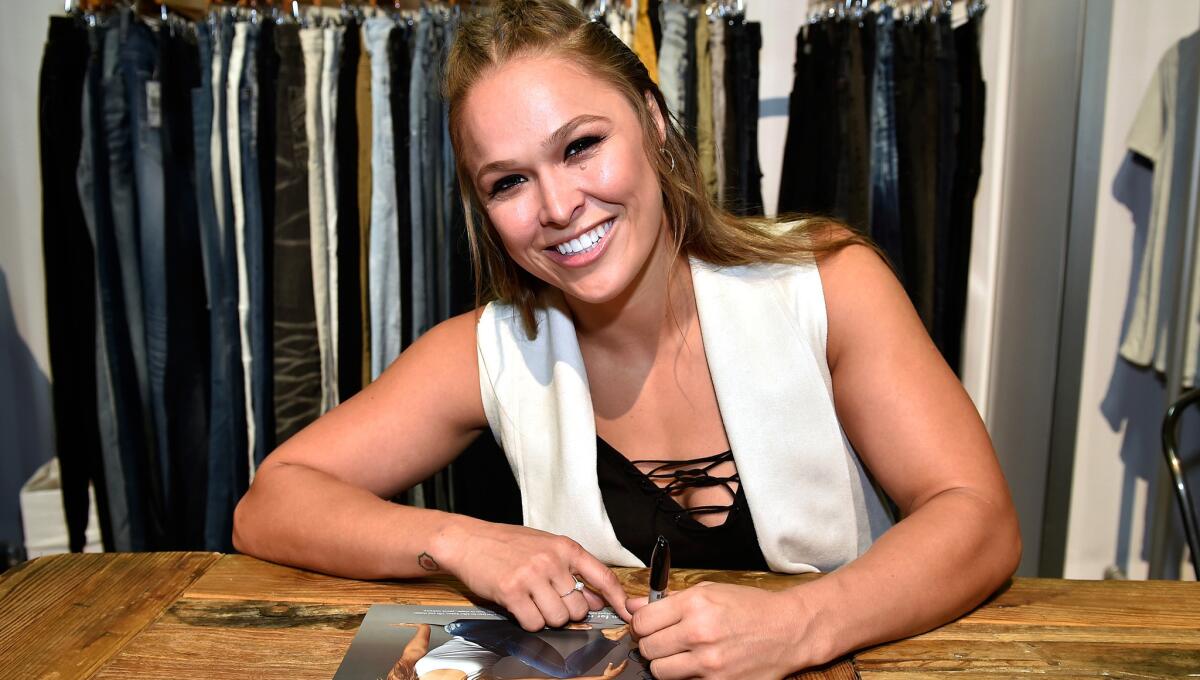 Ronda Rousey signs an autograph at the Buffalo David Bitton booth in Las Vegas during a recent promotion for the clothing company.