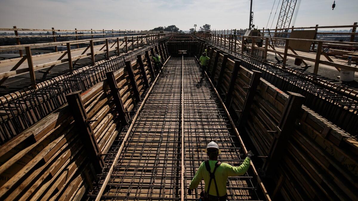 California's high-speed rail project has been dogged by schedule setbacks and cost overruns. Here, workers construct a 3,700-foot viaduct to extend over State Route 99 in Fresno County.