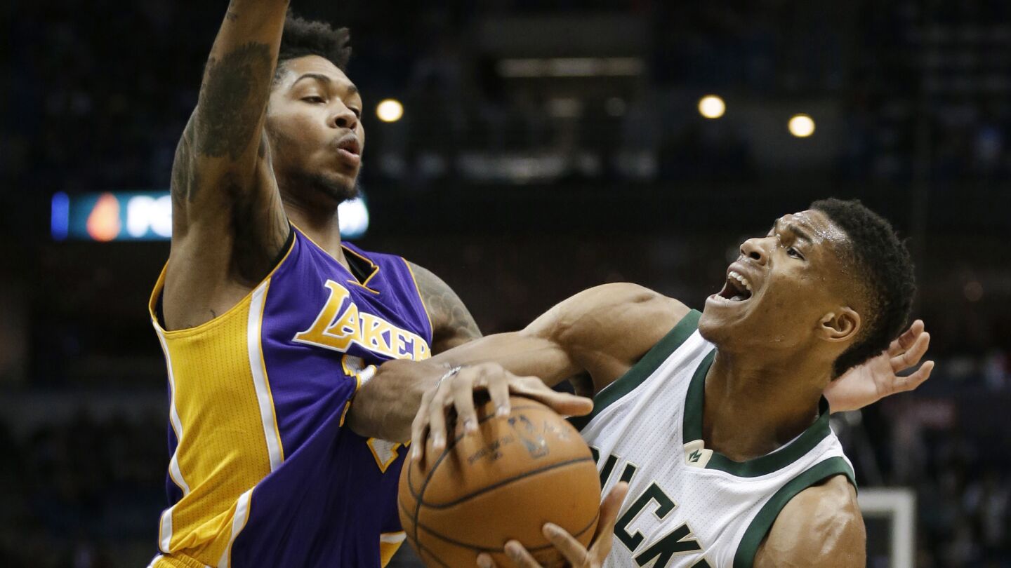 Bucks forward Giannis Antetokounmpo collides with Lakers forward Brandon Ingram on a drive to the basket during the second half.