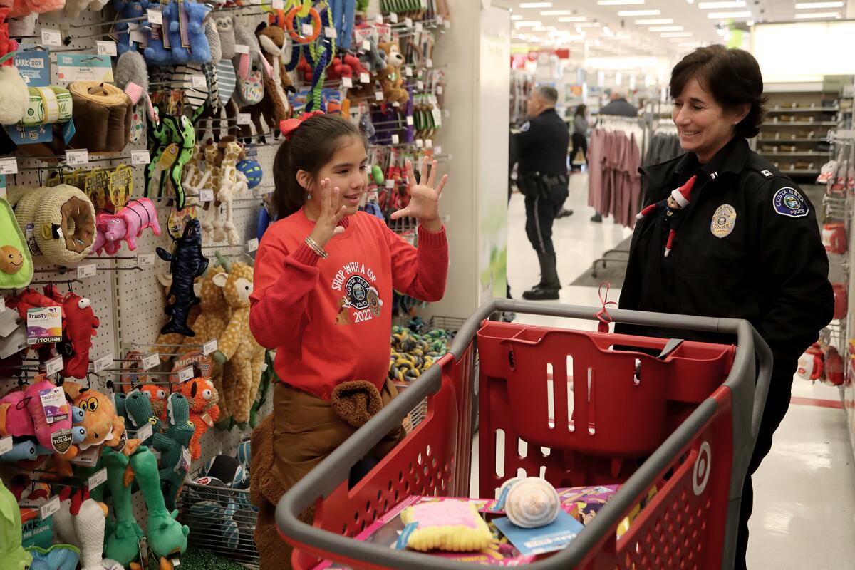 Janelle Corejo, 9, talks to Capt. Joyce LaPointe as they shop during Costa Mesa Police Department's annual event.