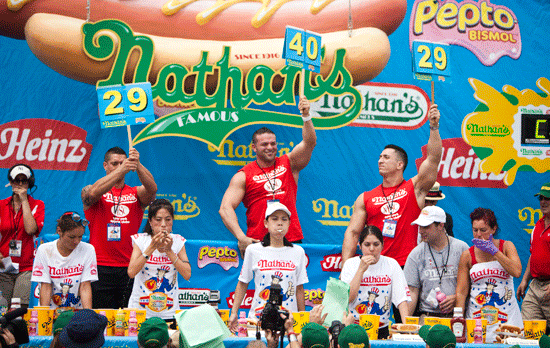 Sonya Thomas (C) competes in the 2011 Nathan's Famous Fourth of July International Hot Dog Eating Contest.