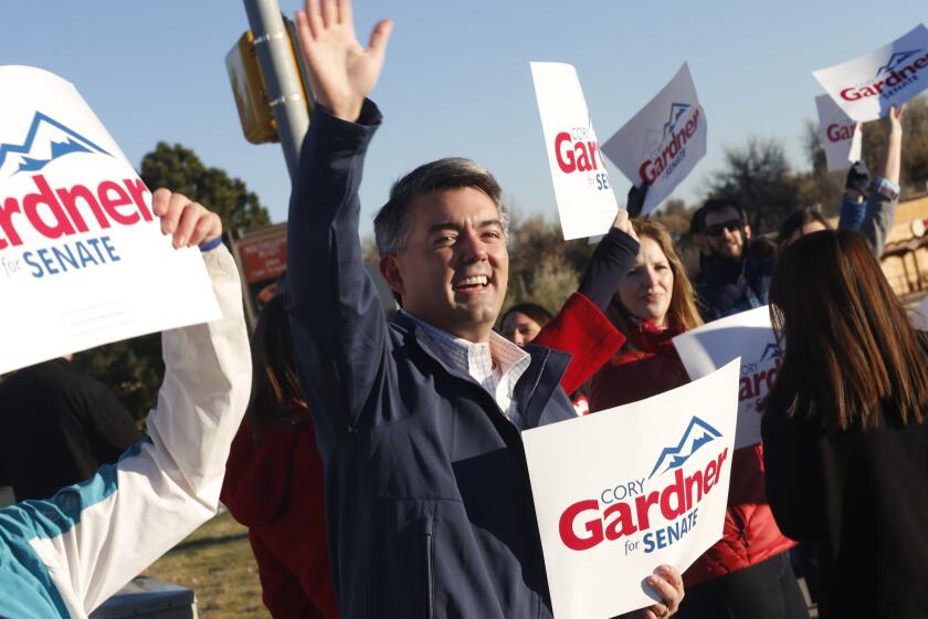 Cory Gardner, Republican candidate for U.S. Senate in Colorado, joins supporters in waving placards on a corner of a major intersection in Centennial, Colo., a suburb of Denver.