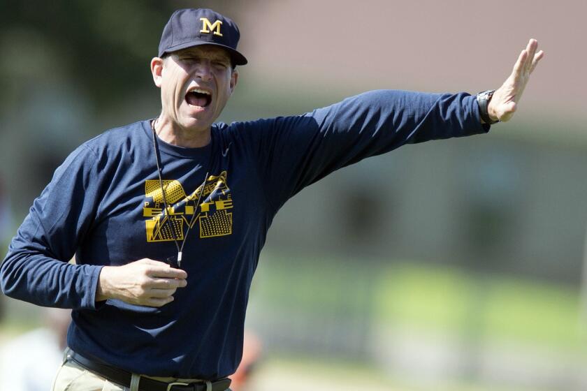 Michigan Coach Jim Harbaugh yells during the Coach Jim Harbaugh's Elite Summer Football Camp, Friday, June 5, 2015, at Prattville High School in Prattville, Ala.
