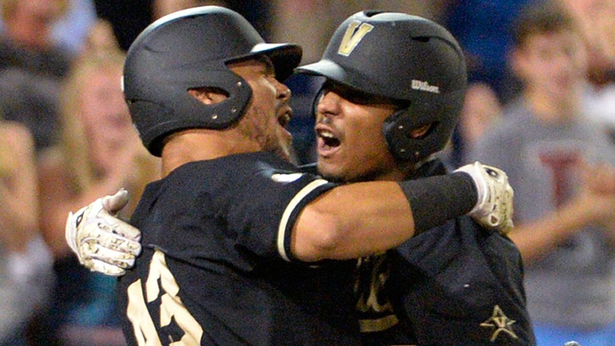 Vanderbilt's John Norwood, right, celebrates with teammate Zander Wiel after hitting a home run during the eighth inning of the Commodores' College World Series title victory over Virginia on Wednesday night.