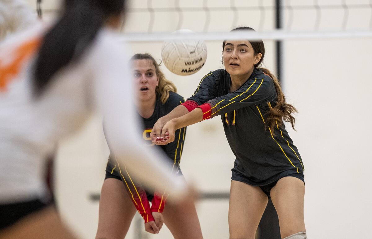 Estancia's Ava Fitzgerald, left, and Leah Perez both attempt to pass a ball during a volleyball match against Los Amigos.