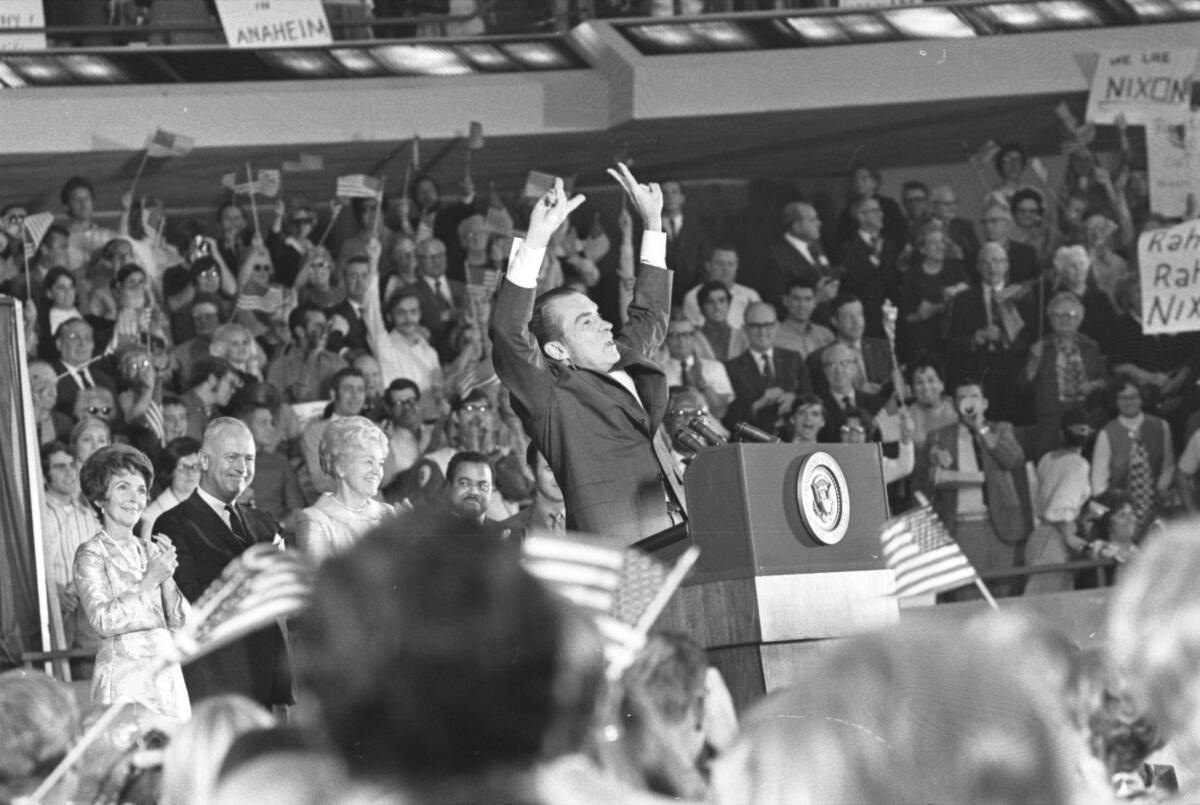 President Nixon raises his arms in a "V" for victory gesture
