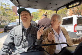 Henry Winkler chats with Times reporter Tom Carroll in a golf cart at the 2024 L.A. Times Festival of Books