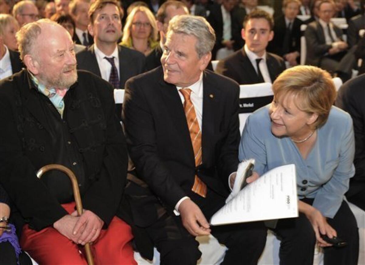 Danish cartoonist Kurt Westergaard, left, speaks with German Chancellor Angela Merkel, right, and Joachim Gauck, center, former head of the state-funded body which manages the archives of the former East German secret police Stasi, before receiving the M100 Media Prize 2010 in Potsdam near Berlin, eastern Germany, Wednesday, Sept 8, 2010. Westergaard drew the most controversial of 12 caricatures of the Prophet Mohammed, first published in a Danish newspaper in 2005, which many Muslims considered offensive. (AP Photo/Odd Andersen, pool)