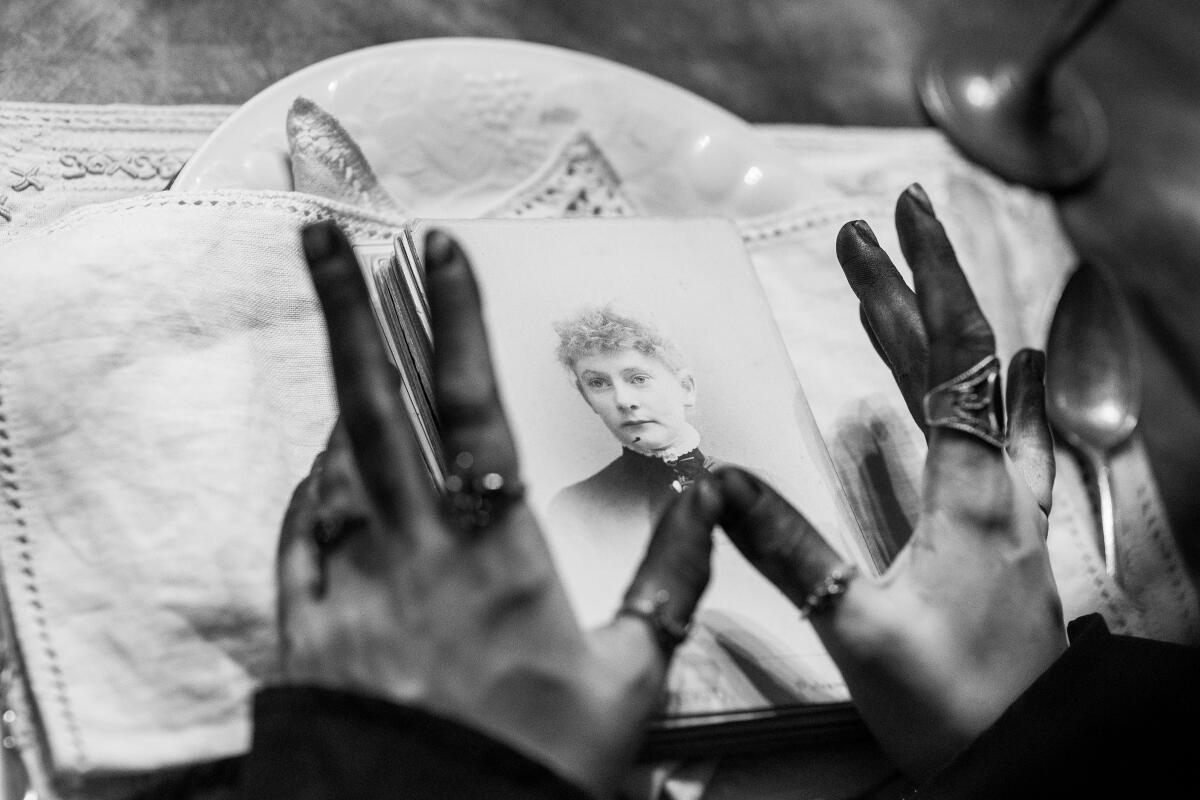 Creepy hands hover over a black and white portrait