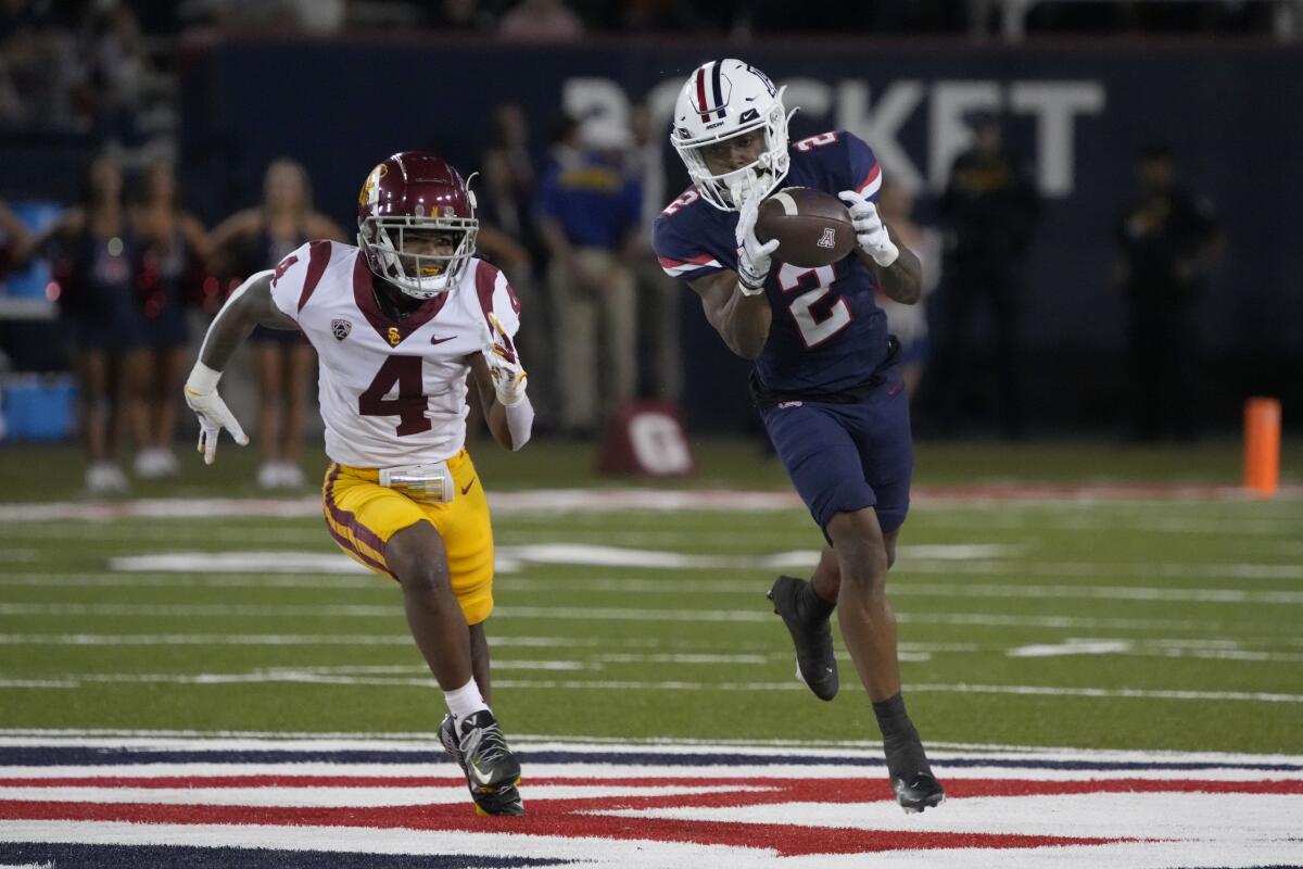 Arizona wide receiver Jacob Cowing catches a pass in front of defensive back Max Williams during the Trojans' win Oct. 29.