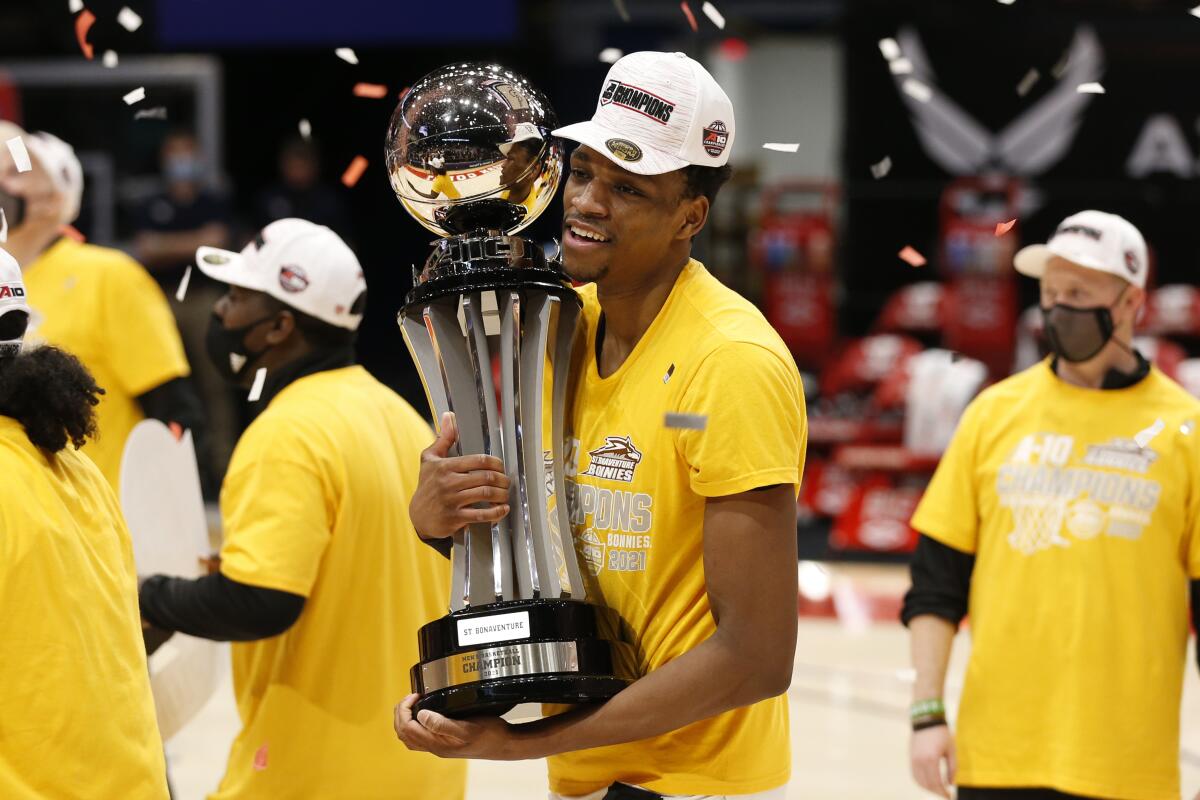 St. Bonaventure's Osun Osunniyi celebrates with the trophy after beating VCU in an NCAA college basketball championship game for the Atlantic Ten Conference tournament Sunday, March 14, 2021, in Dayton, Ohio. St. (AP Photo/Jay LaPrete)