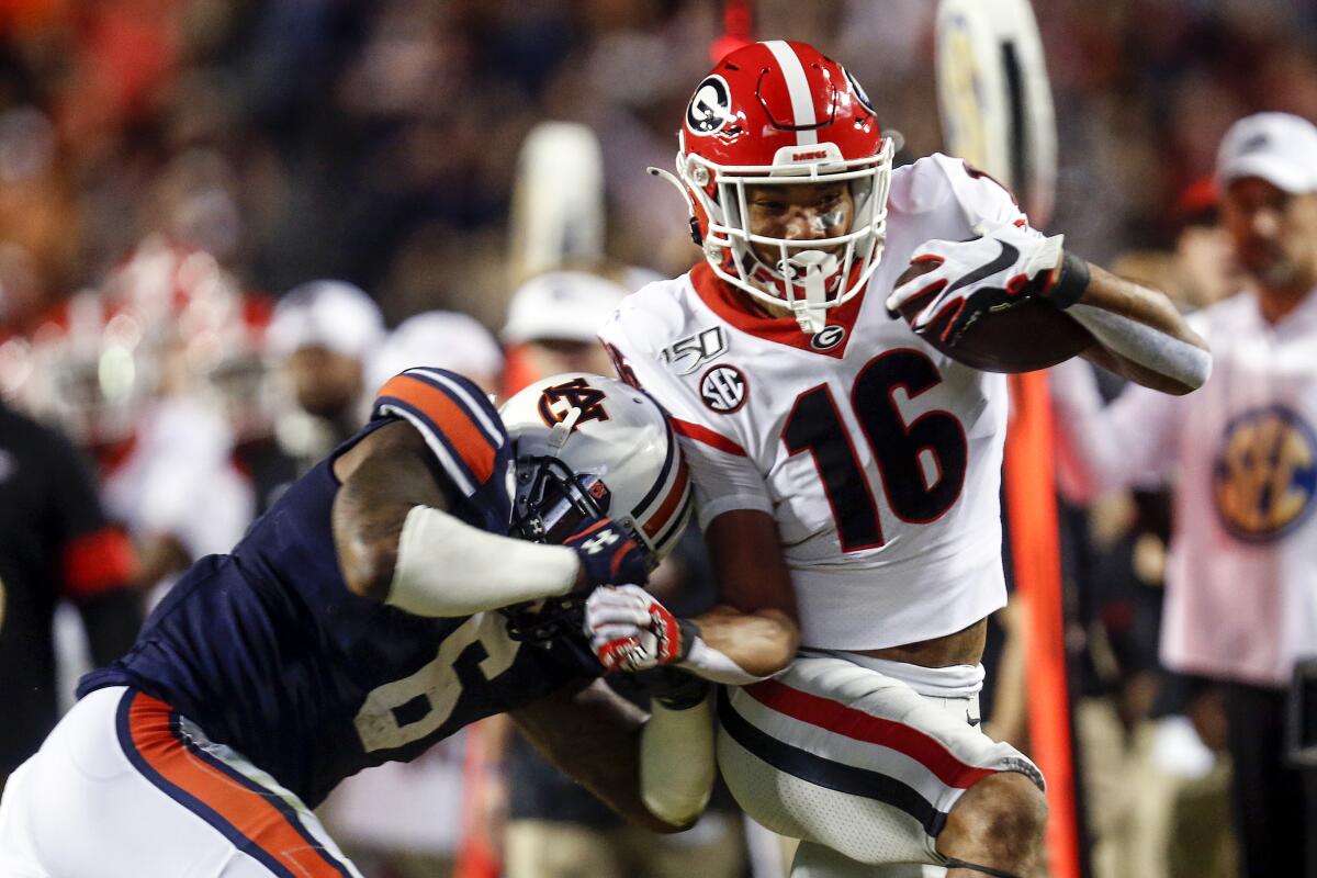 Georgia wide receiver Demetris Robertson is knocked out of bounds by Auburn defensive back Christian Tutt.