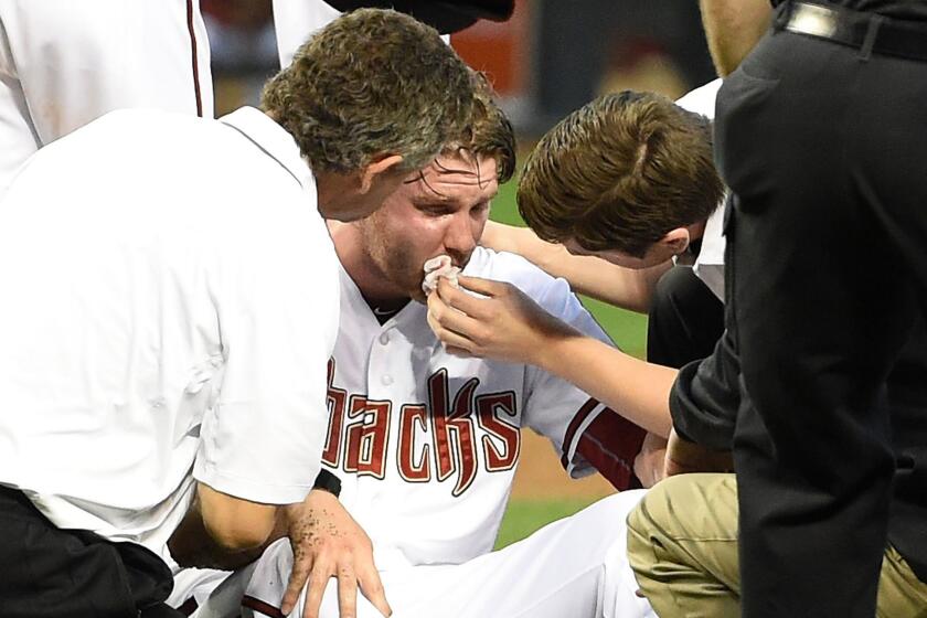 Arizona Diamondbacks pitcher Archie Bradley receives medical attention after taking a line drive off the right side of his face during a win over the Colorado Rockies in Phoenix on April 28.