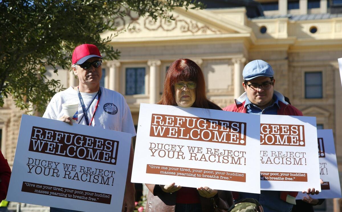 Demonstrators in favor of welcoming Syrian refugees attend a rally in Phoenix, Ariz. on Nov. 17. Arizona Gov. Doug Ducey has joined a growing number of governors calling for an immediate halt to the placement of any new refugees in the wake of terrorist attacks in Paris.
